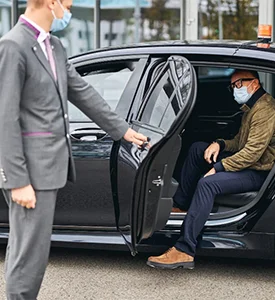 Professional chauffeur assisting customer