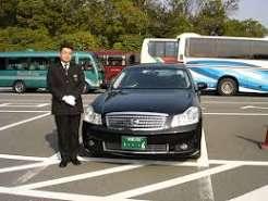 Man standing next to a black luxury car,